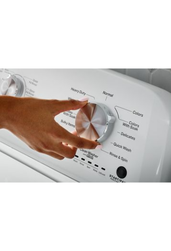 Hand adjusting metallic cycle selector knob on white top load washer from washers and appliances collection