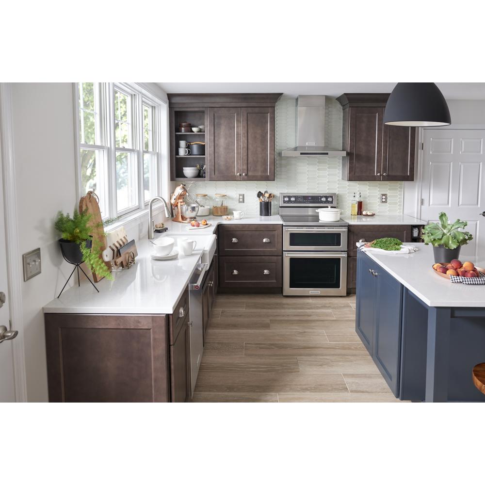 modern kitchen with stainless steel double oven electric range, dark wood cabinets, and blue island in home improvement setting