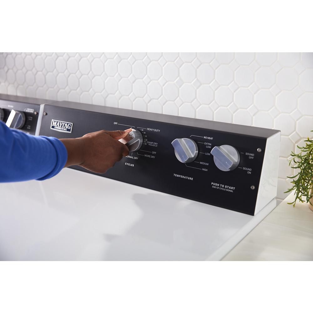 Hand adjusting cycle selector on black control panel of commercial-grade electric dryer from Dryers collection