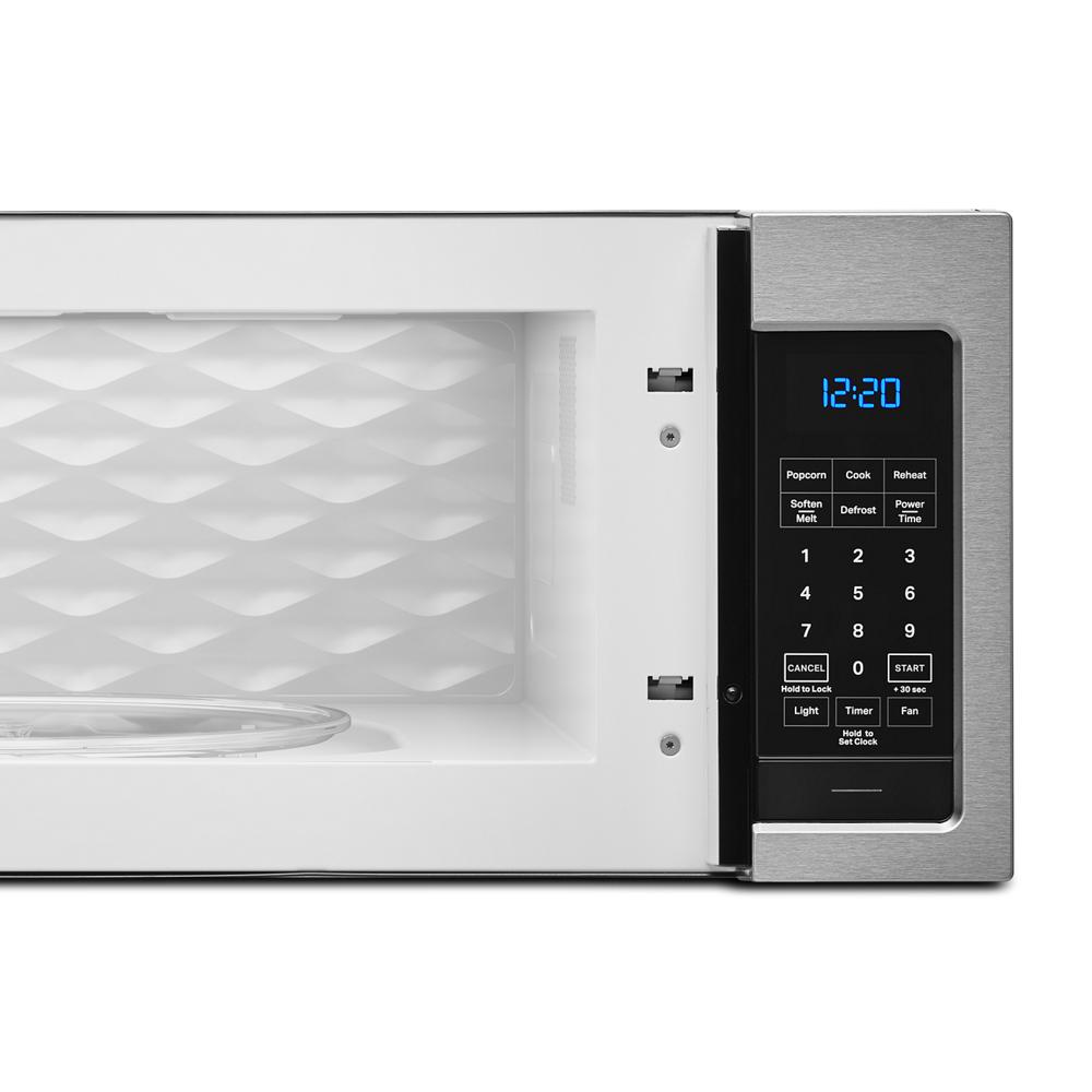 Close-up of digital control panel and white interior with textured back panel on kitchen microwave in appliances collection