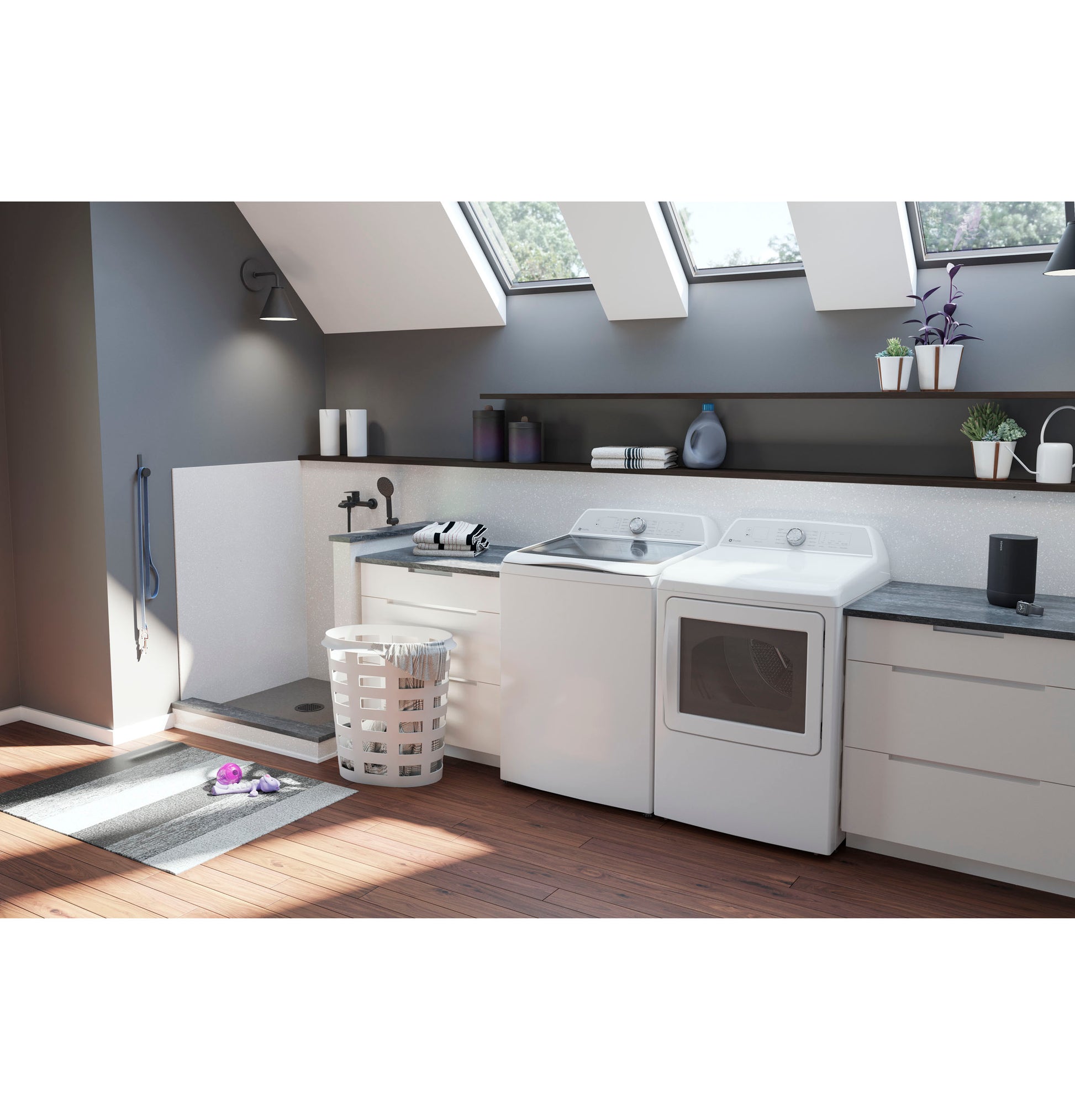 Laundry room featuring white top load washer and dryer set with natural light from skylights and modern cabinetry