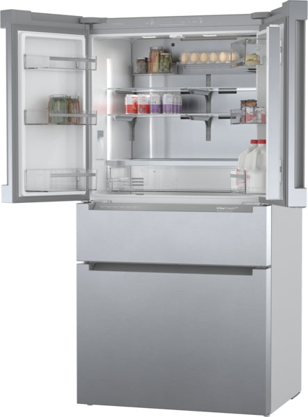 Open stainless steel French door bottom mount refrigerator showing organized interior shelves and storage compartments