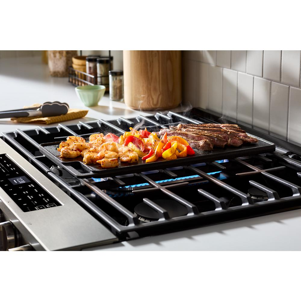 Close-up of 30-inch gas range cooktop with griddle cooking shrimp, steak, and bell peppers in kitchen setting