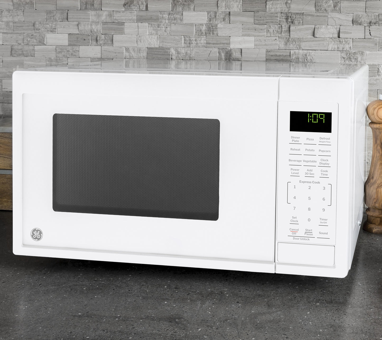 White countertop microwave with digital control panel and timer, set against modern stone tile backsplash in kitchenware collection