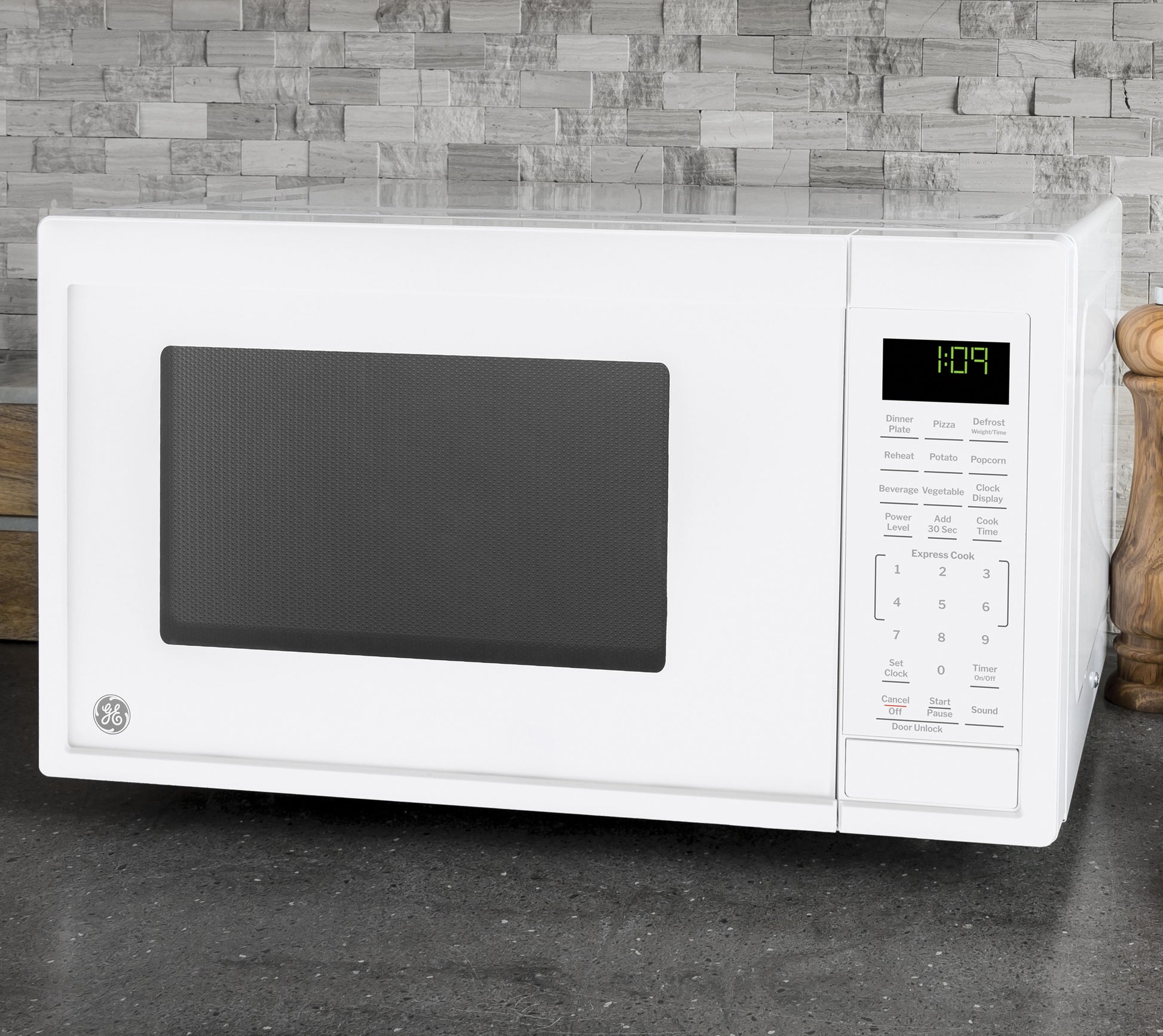 White countertop microwave with digital control panel and timer, set against modern stone tile backsplash in kitchenware collection