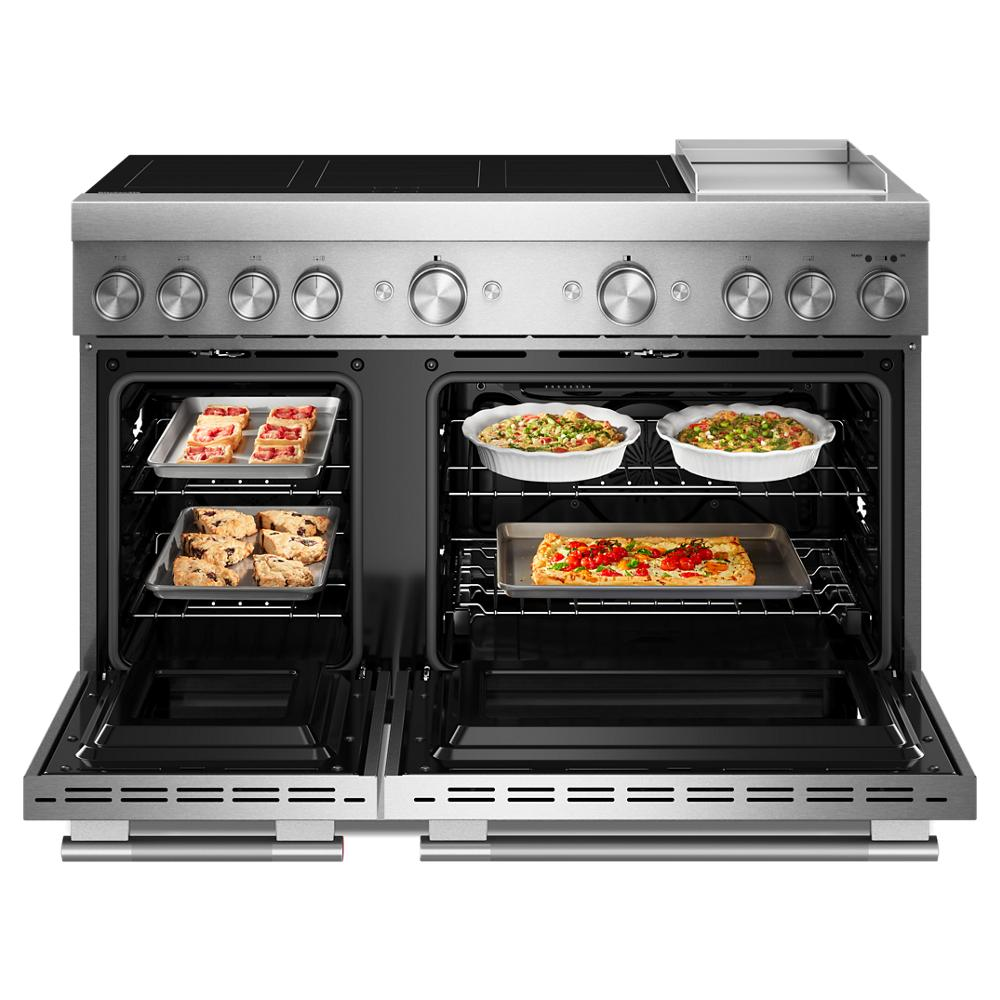 Commercial-style stainless steel induction range with open double ovens cooking pizzas, casseroles, and baked goods