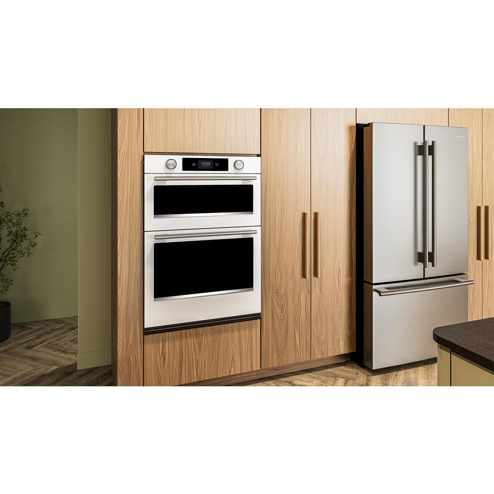 Built-in white electric combo wall oven with touchscreen and backlit knobs in modern kitchen cabinetry setting