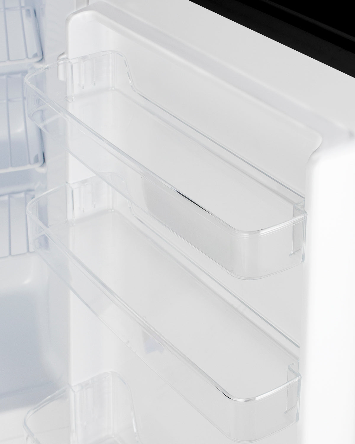 Clear plastic door bins inside white built-in undercounter all-freezer for kitchen and appliance storage.