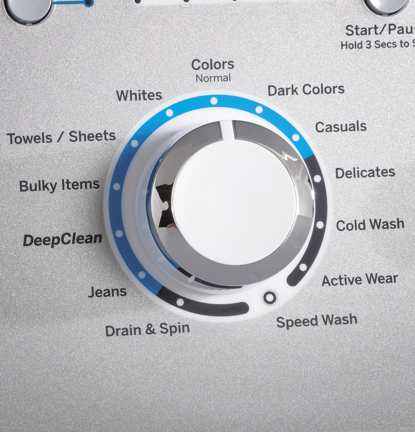 Close-up of silver cycle selection dial on top load washer with settings like Colors, Whites, Delicates, and Speed Wash