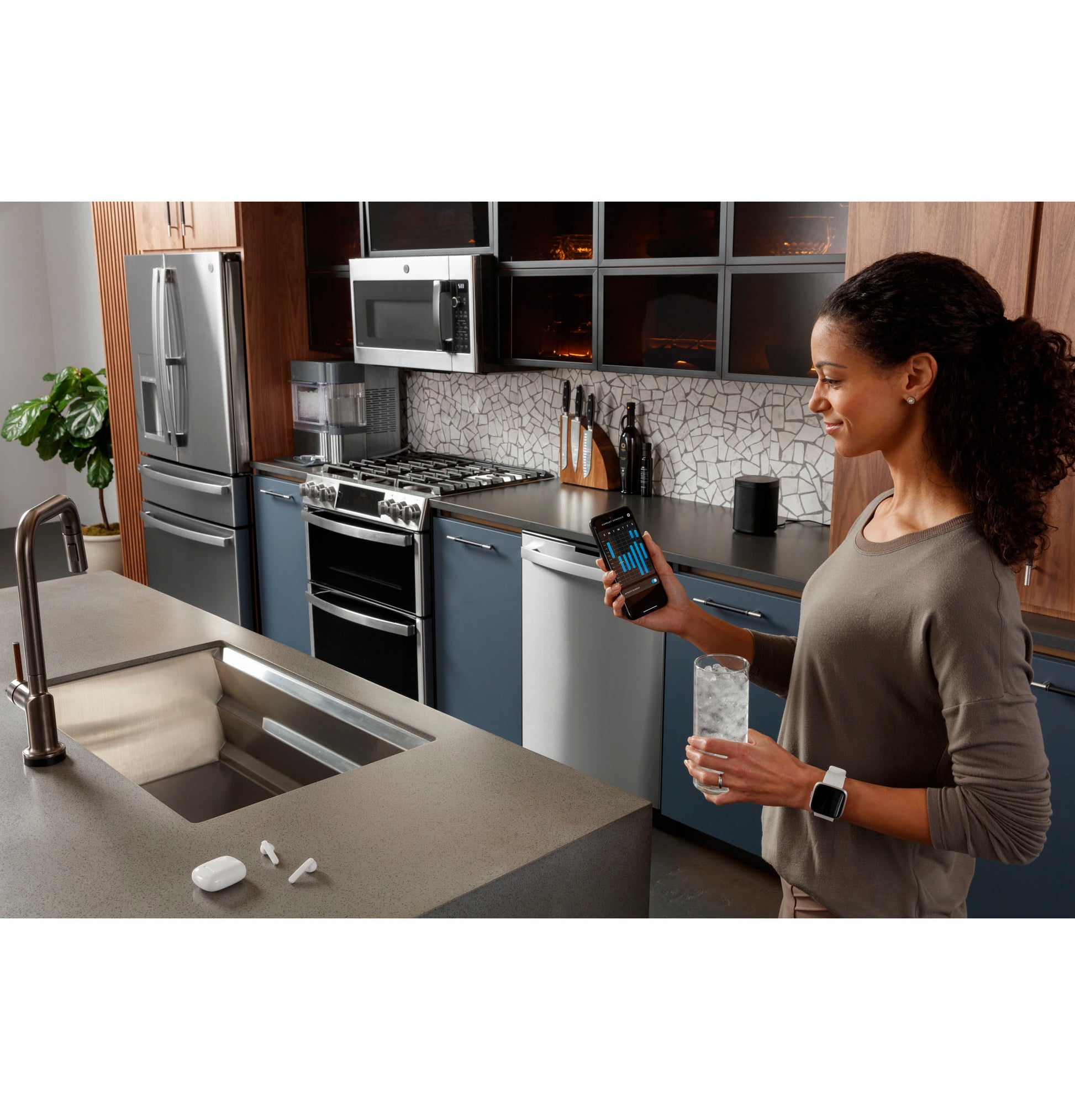 Modern kitchen with stainless steel slide-in gas double oven range, refrigerator, and blue lower cabinets from Ranges collection