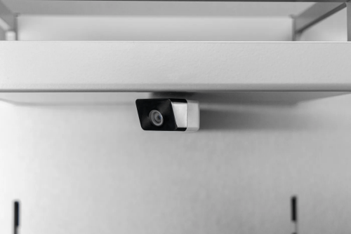 Close-up of stainless steel small internal camera or sensor inside modern built-in refrigerator appliance interior panel