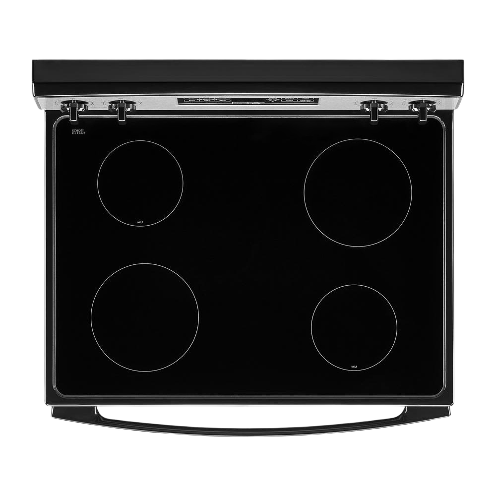 Top view of smooth black electric cooktop with four circular burners and stainless steel trim in kitchen appliances collection