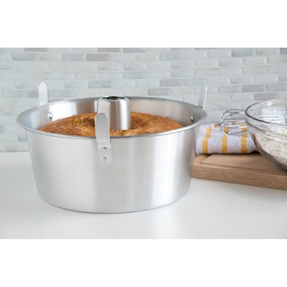 Aluminum loose bottom cake pan with center tube and locking clips holding a baked angel food cake inside