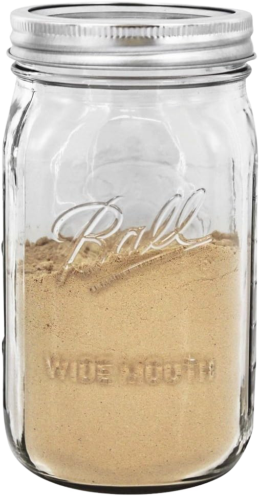 Clear wide mouth quart jar with silver metal lid filled halfway with light brown powder in kitchenware collection