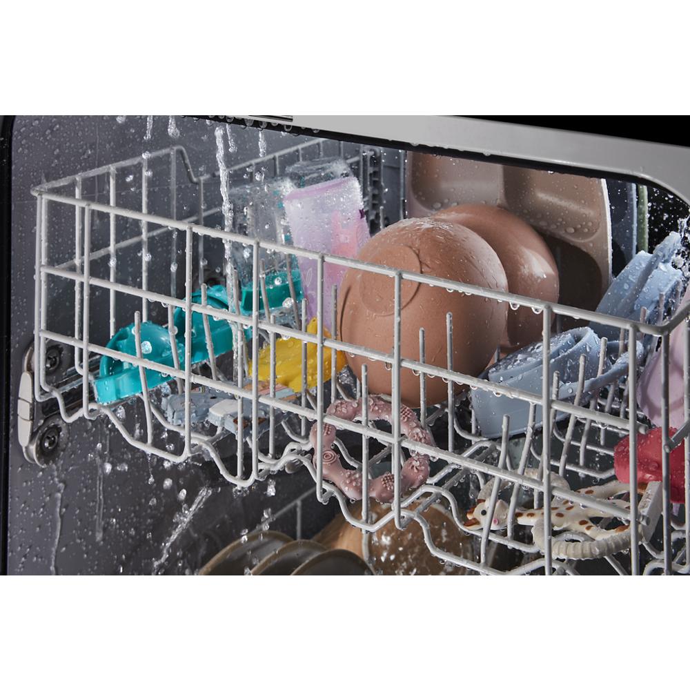 Water sprays inside dishwasher rack loaded with various kitchenware and utensils in modern appliances setup