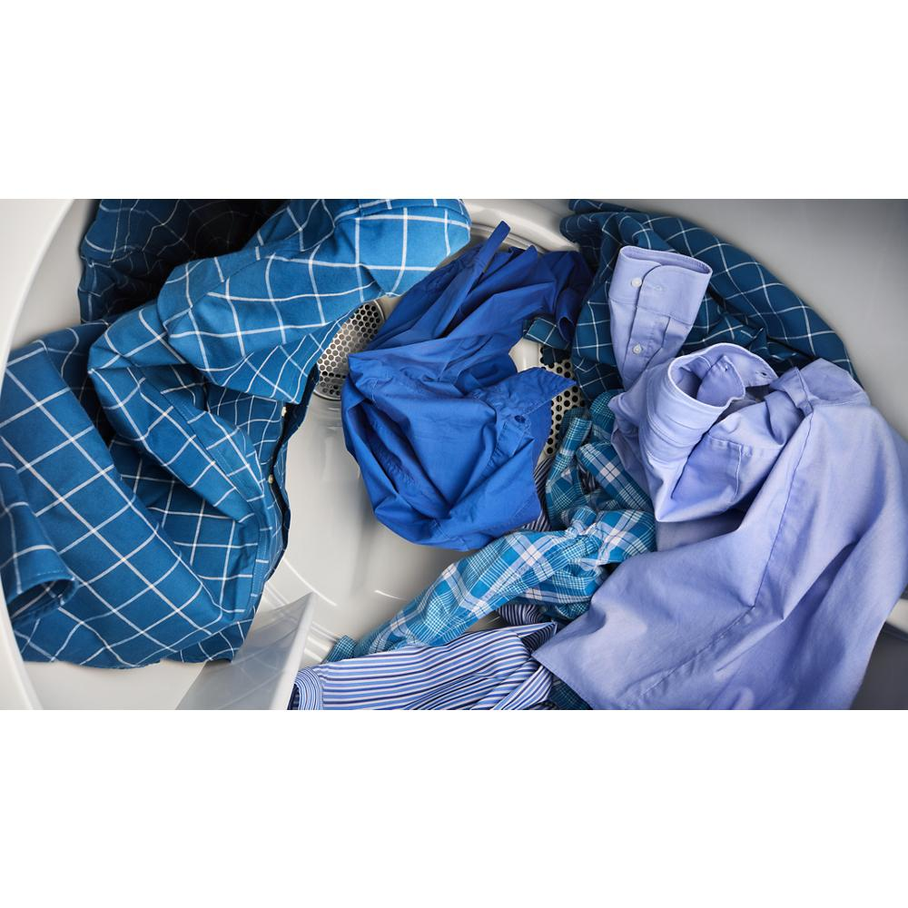 Close-up of various blue shirts tumbling inside a dryer drum in the washers and dryers appliance collection