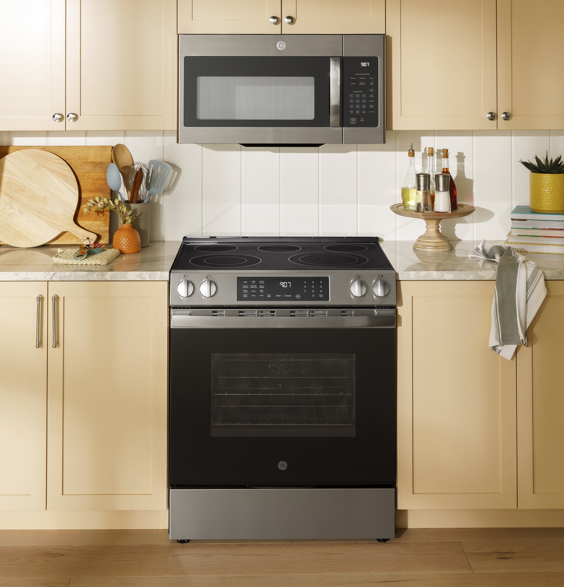 Front view of black and stainless steel electric slide-in range with smooth cooktop in modern kitchen setting
