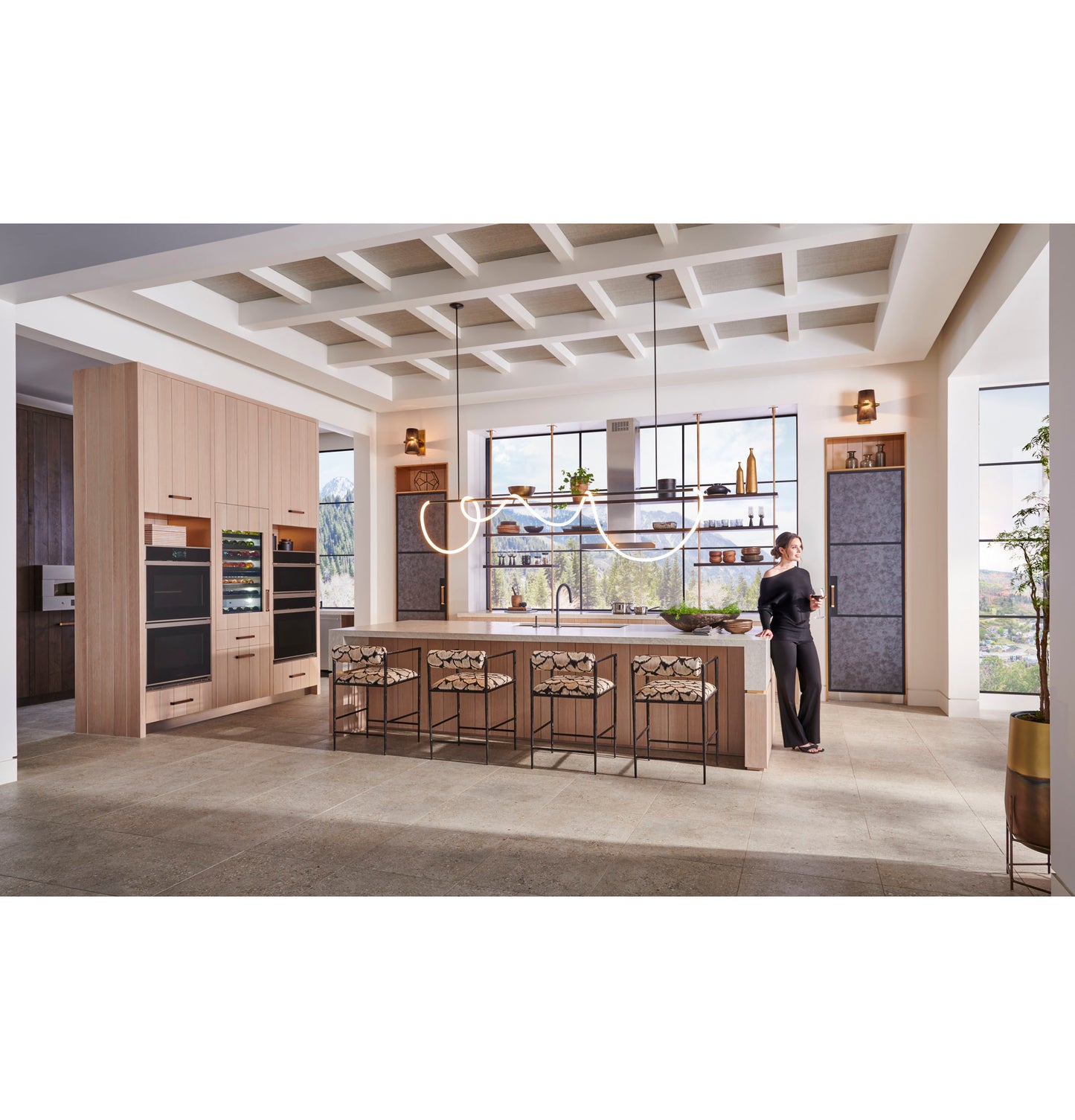 Modern kitchen with minimalist double wall ovens, wooden cabinetry, large island with seating, and wide window views in appliances collection