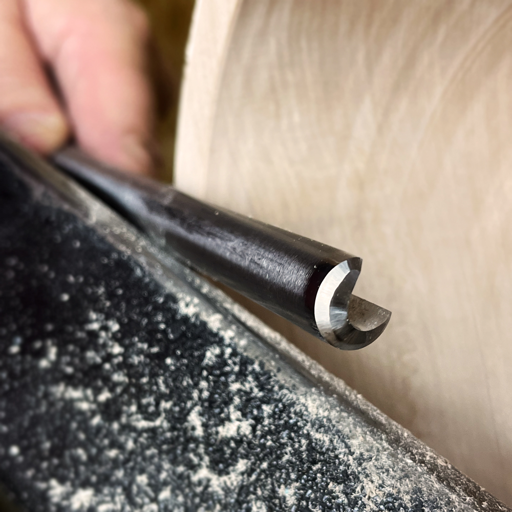 Close-up of a bowl turning gouge shaping wood on a lathe in woodworking tools and home improvement collection