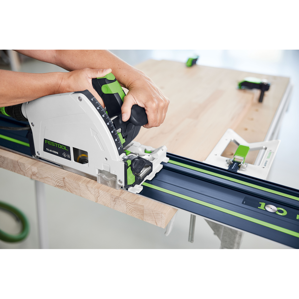 Hands operating a Festool power saw on a blue guide rail cutting a wooden board for tools and home improvement