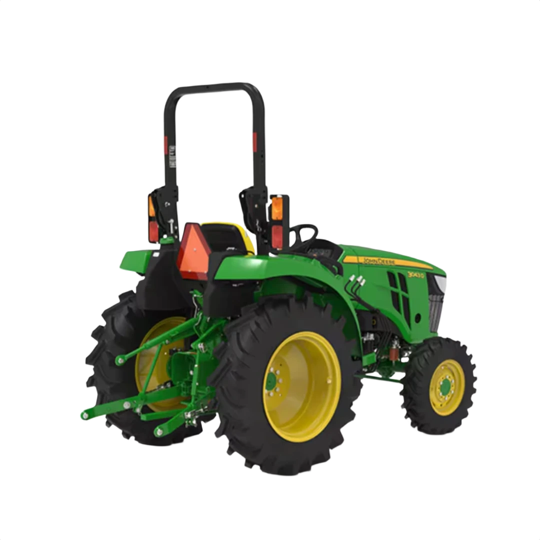Rear view of green and yellow compact tractor with rollover protection and rear hitch for agricultural and home improvement use