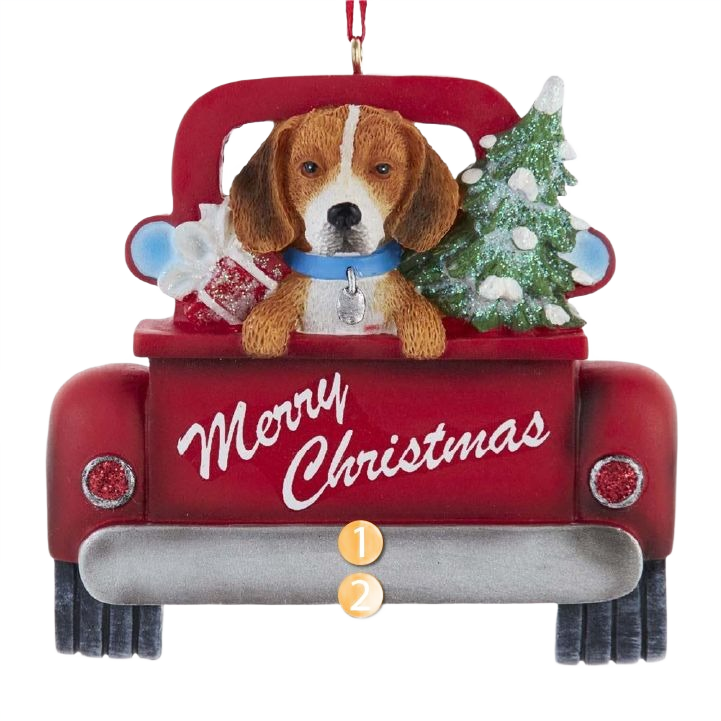 Beagle dog with blue collar sitting in red truck bed holding a decorated Christmas tree and gift box ornament