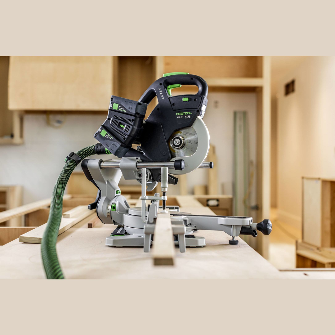 Cordless compound miter saw on woodbench in workshop, battery powered woodworking and electric power tool.