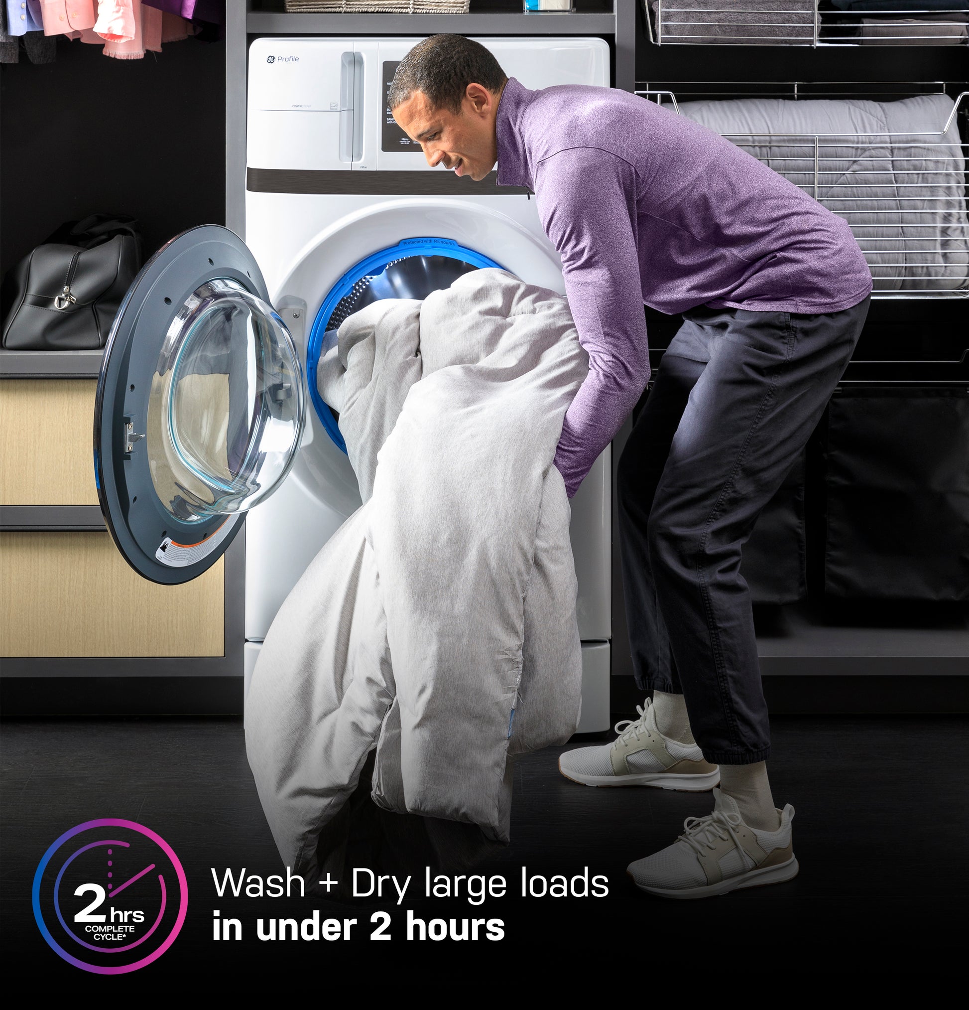 Man loading large comforter into white front load washer dryer combo in modern laundry room setting