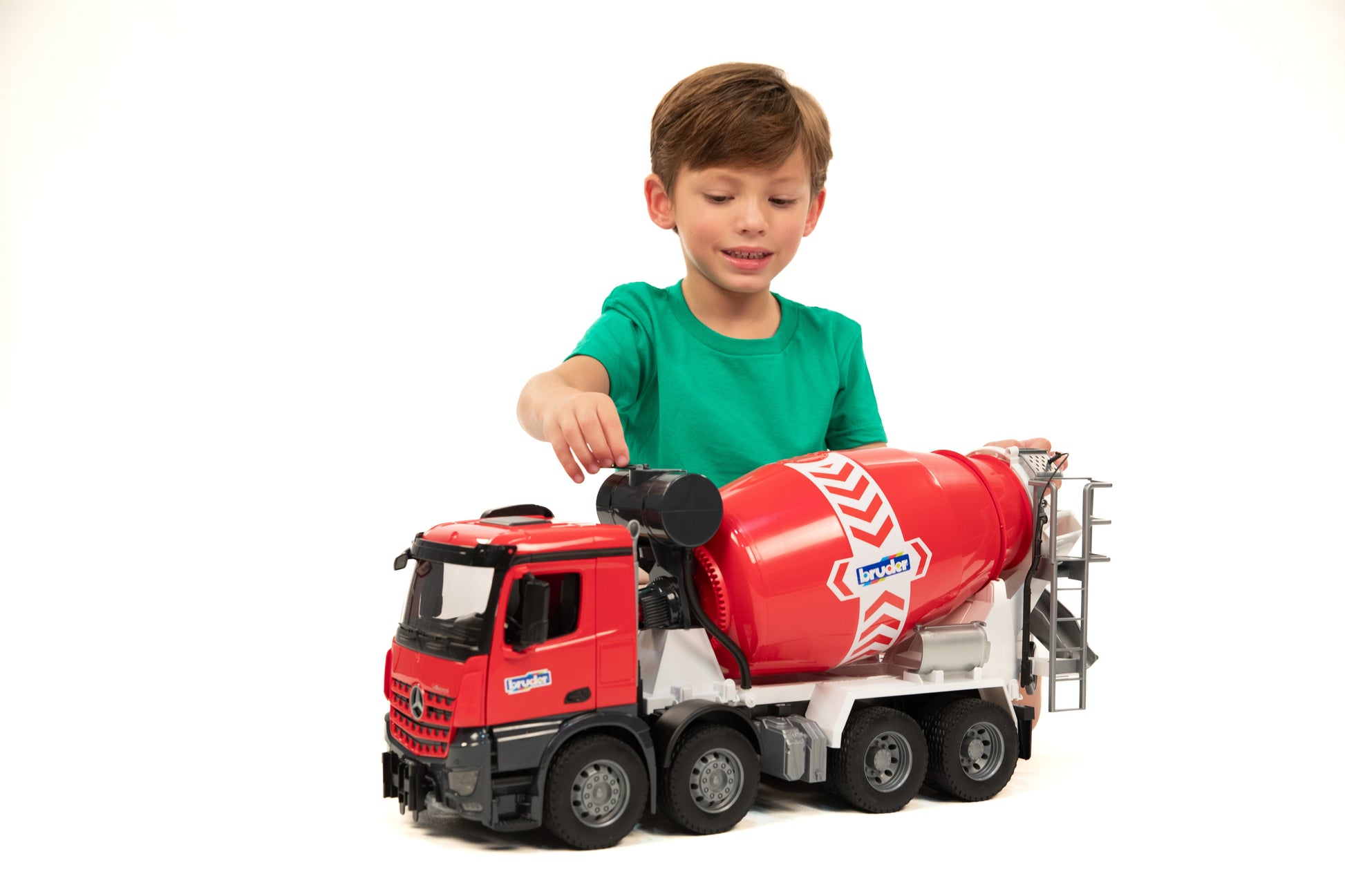 Child in green shirt playing with red cement mixer toy truck featuring rotating drum and detailed cab for imaginative play