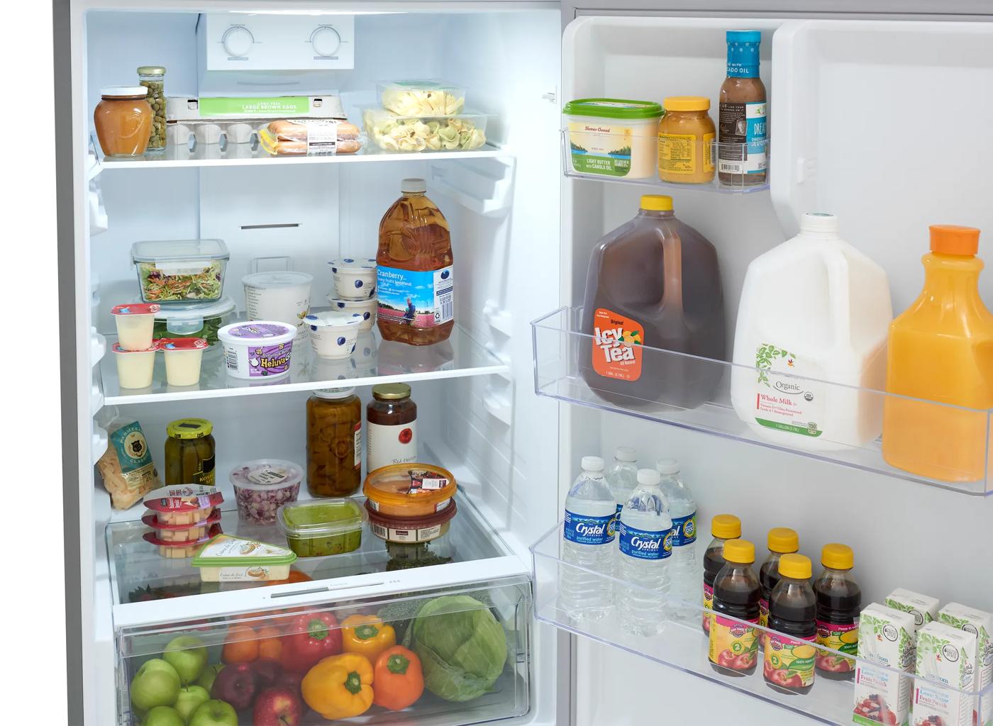 Open fridge with organized shelves holding beverages, dairy, fresh produce, and condiments for kitchen and appliance use