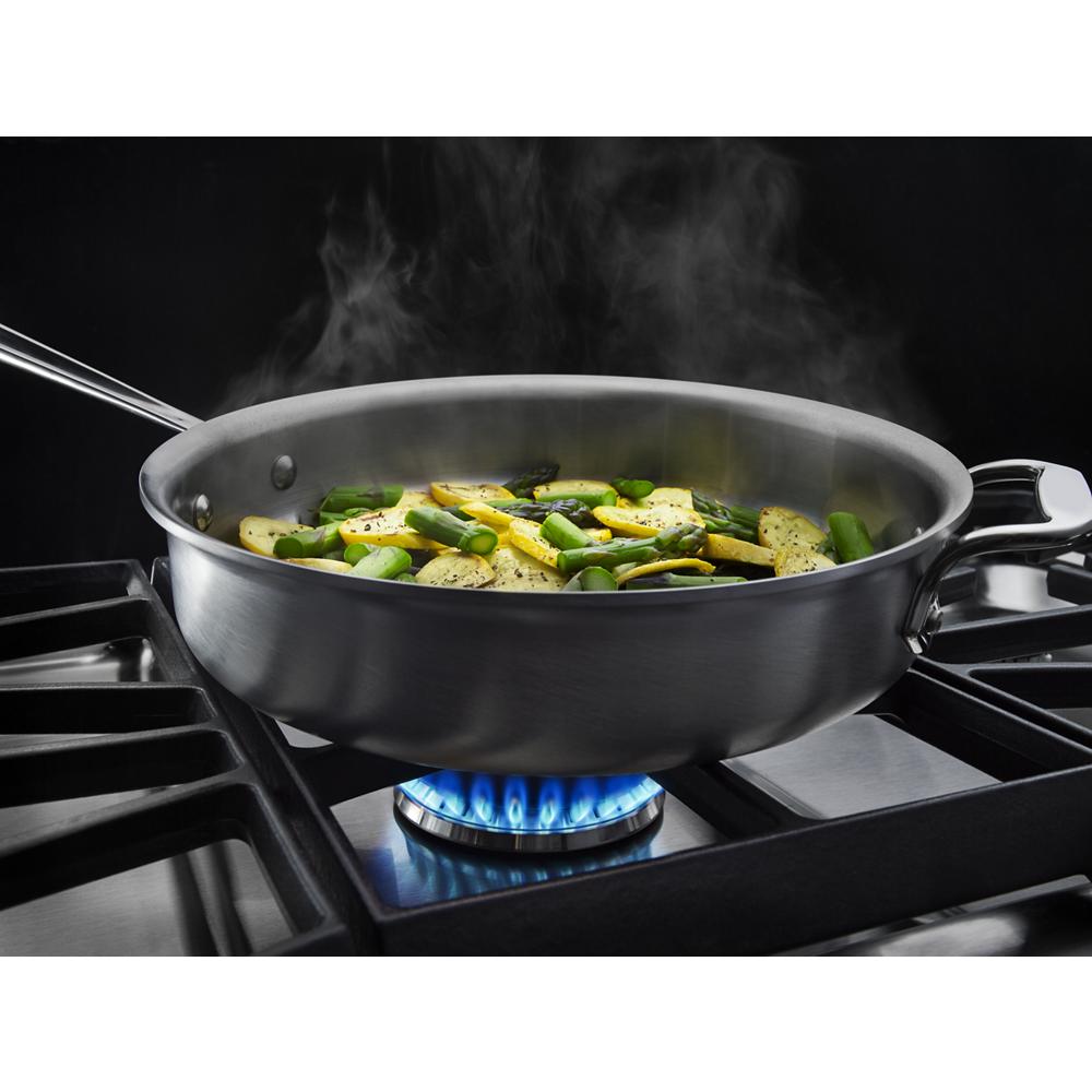 Steaming vegetables cooking in stainless steel skillet on gas burner flame in kitchenware cooktops collection