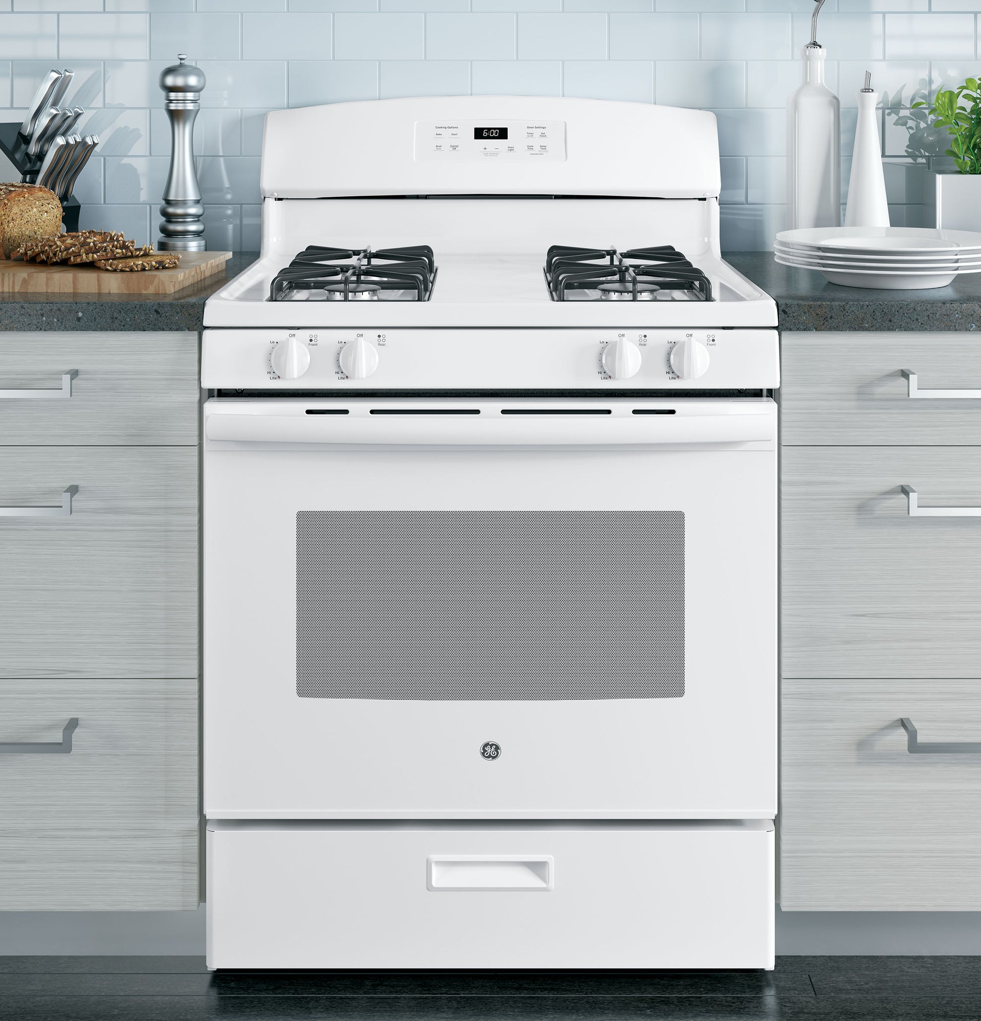 Front-facing white freestanding gas range with four burners and digital control panel in modern kitchen setting