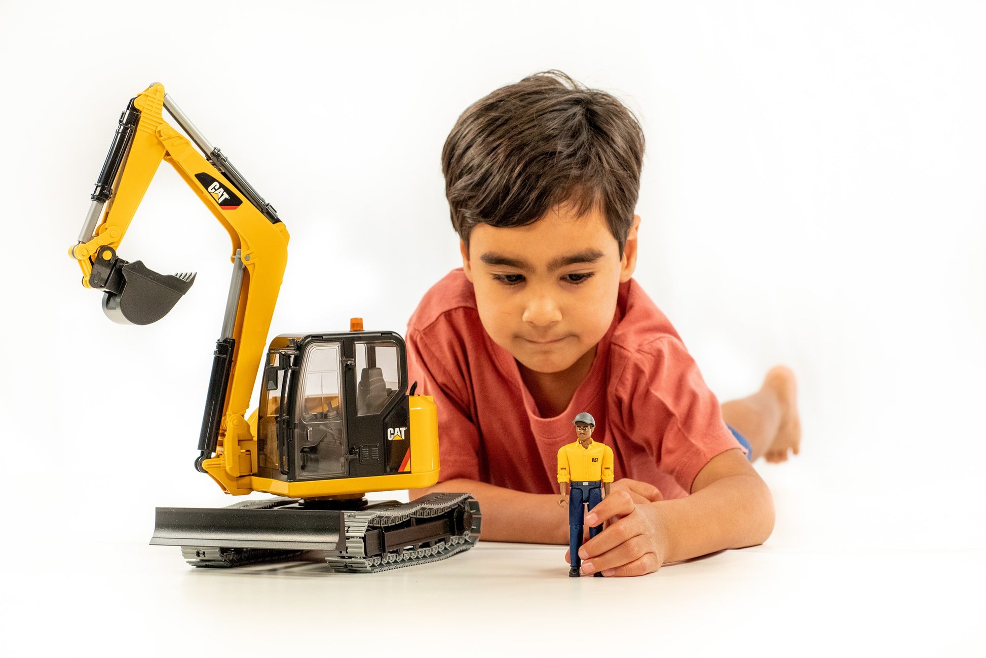 Child playing with yellow Bruder Cat mini excavator toy and detailed worker figure for construction role play activities