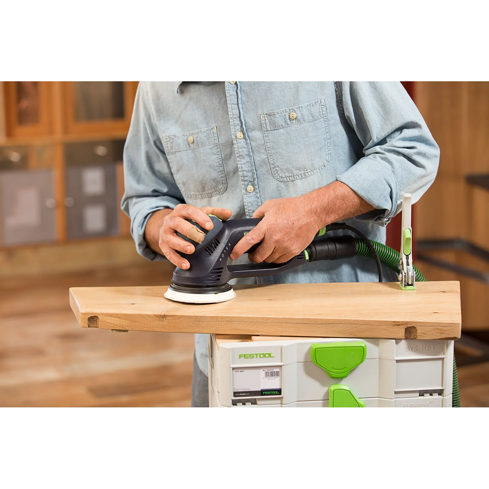 Man using Festool sander with dust extraction hose to smooth wooden plank for home improvement and power tool use