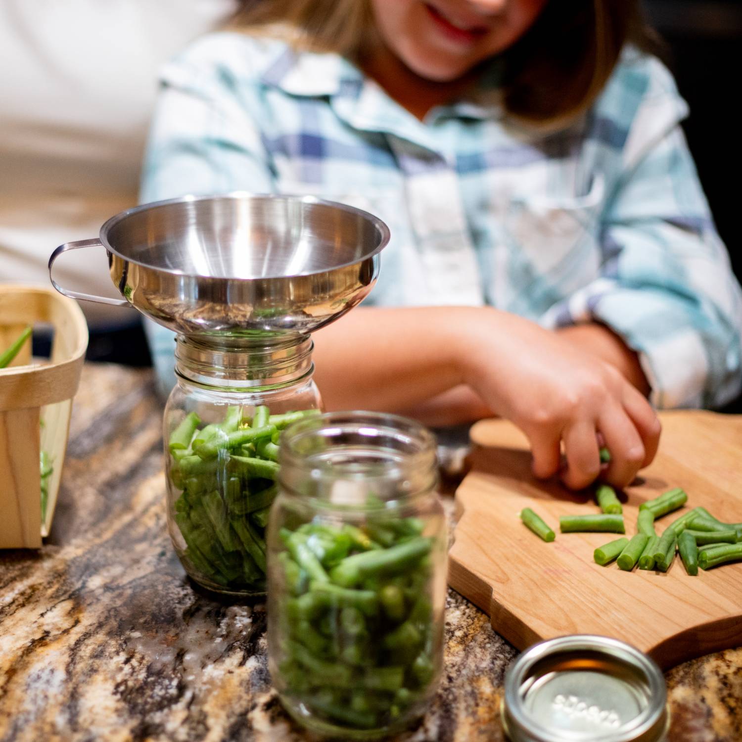 Stainless steel funnel with removable spout filling glass jar with green beans on kitchen countertop under $50 kitchenware