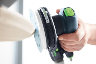 Corded random orbit sander with ergonomic grip, used for smoothing wood surfaces in home improvement projects