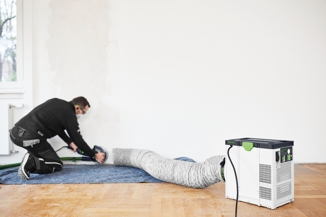 Portable air filtration unit connected to flexible ducting used during indoor renovation work for dust control
