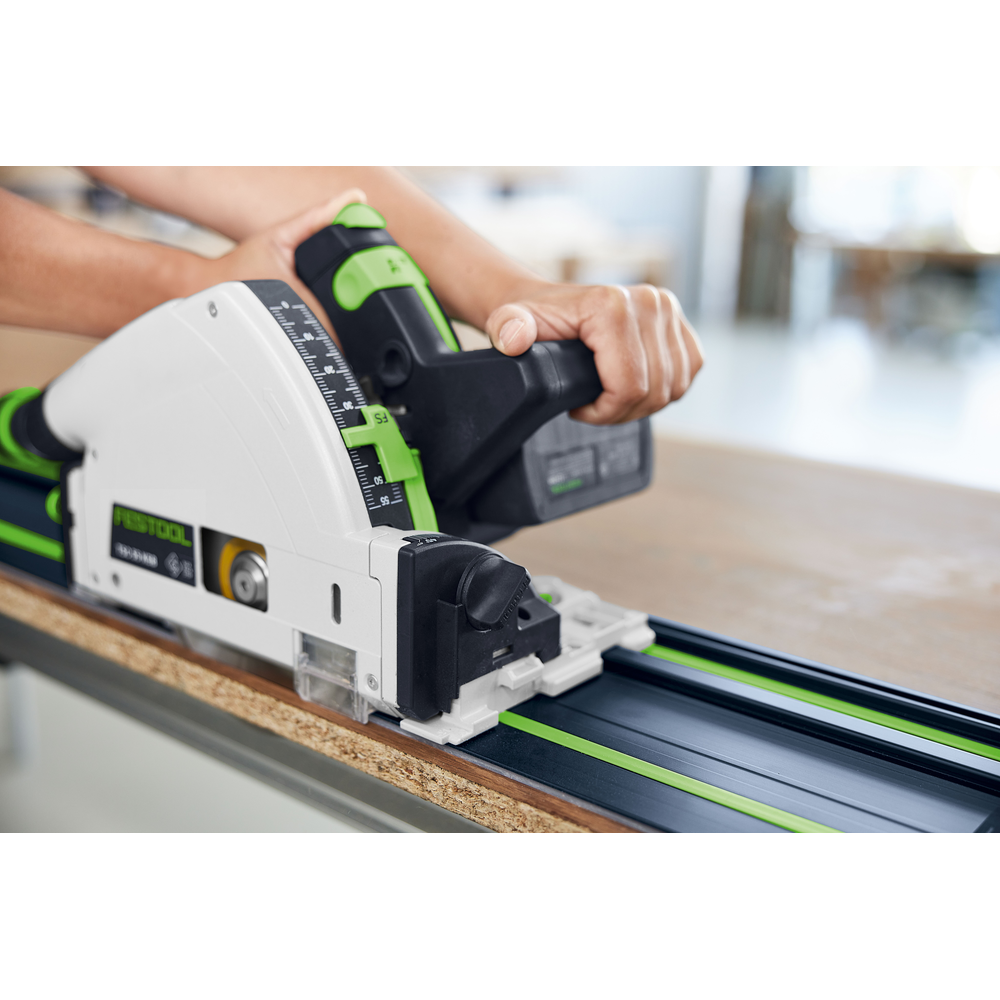 Close-up of a power tool cutting wood using a blue and green guide rail for precise home improvement tasks