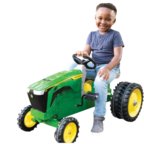 Young child riding green and yellow pedal tractor toy from vehicles and toys collection for outdoor play