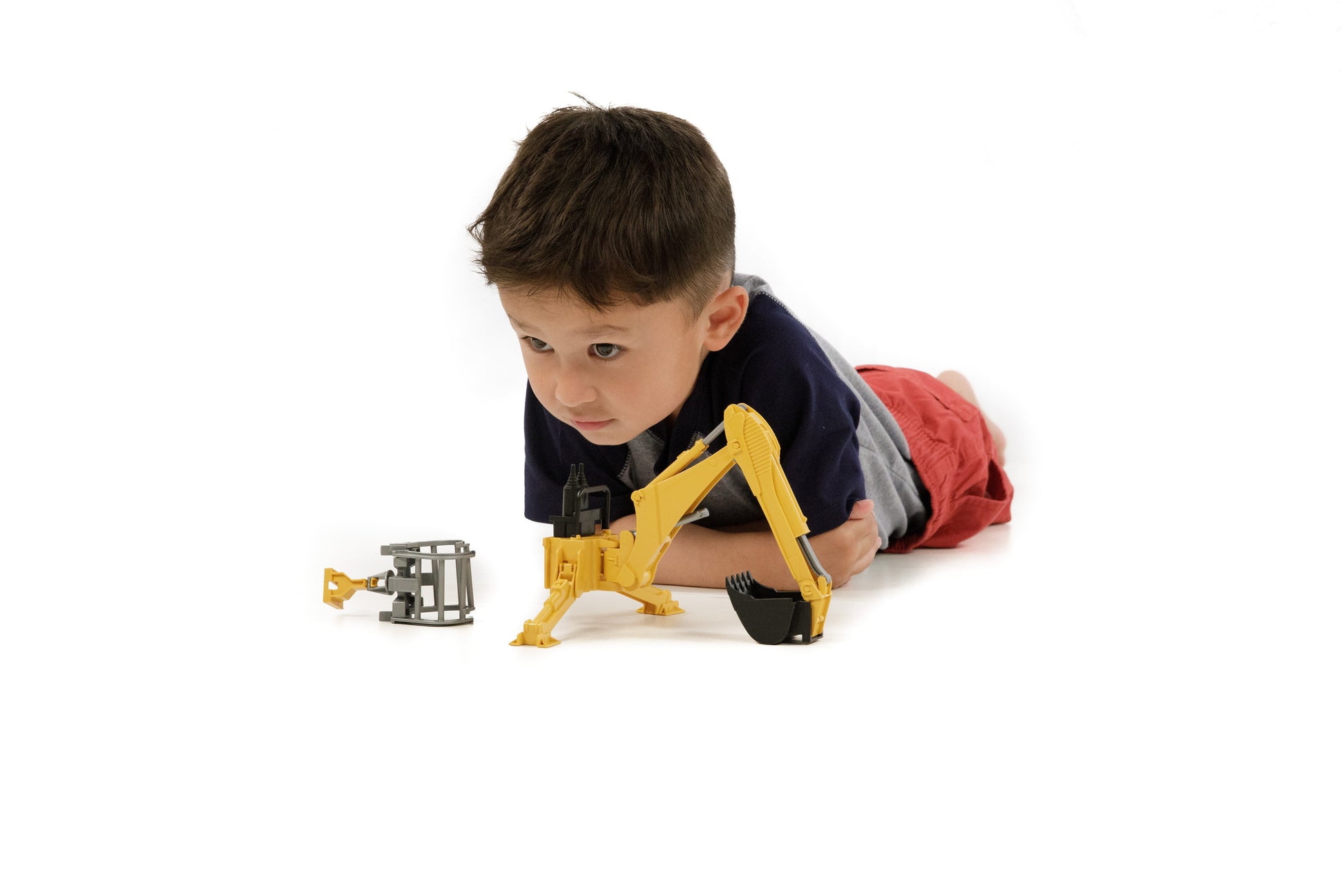 Child playing with yellow Bruder rear hydraulic arm toy for tools and home improvement activities