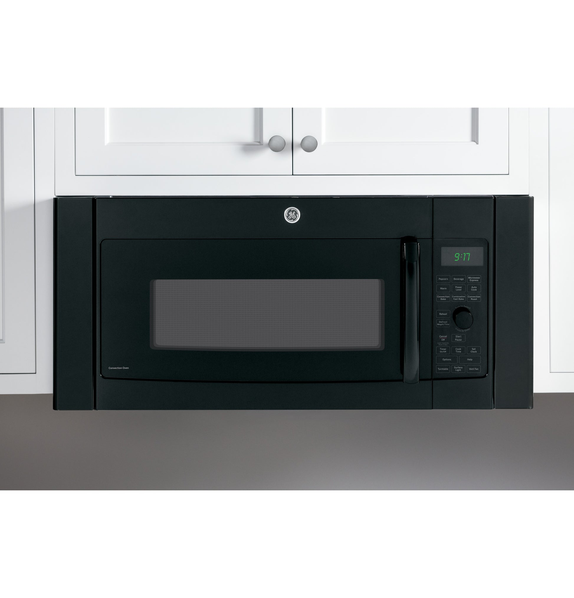 Black built-in spacer kit surrounding overhead microwave between white kitchen cabinets in Appliances collection