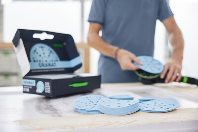 Blue sanding discs being prepared from a starter set box for tools and home improvement projects
