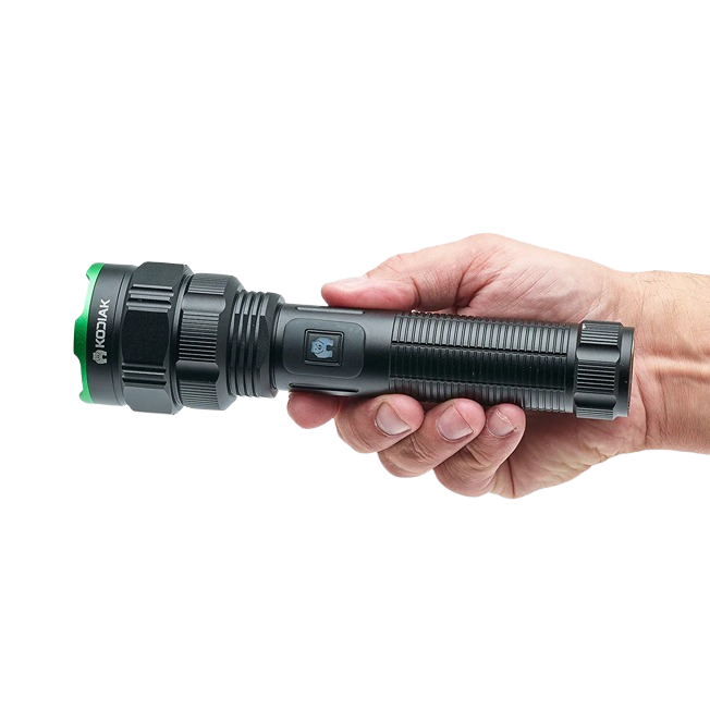 Black tactical flashlight with green bezel held in hand featuring textured grip and side power button for tools use