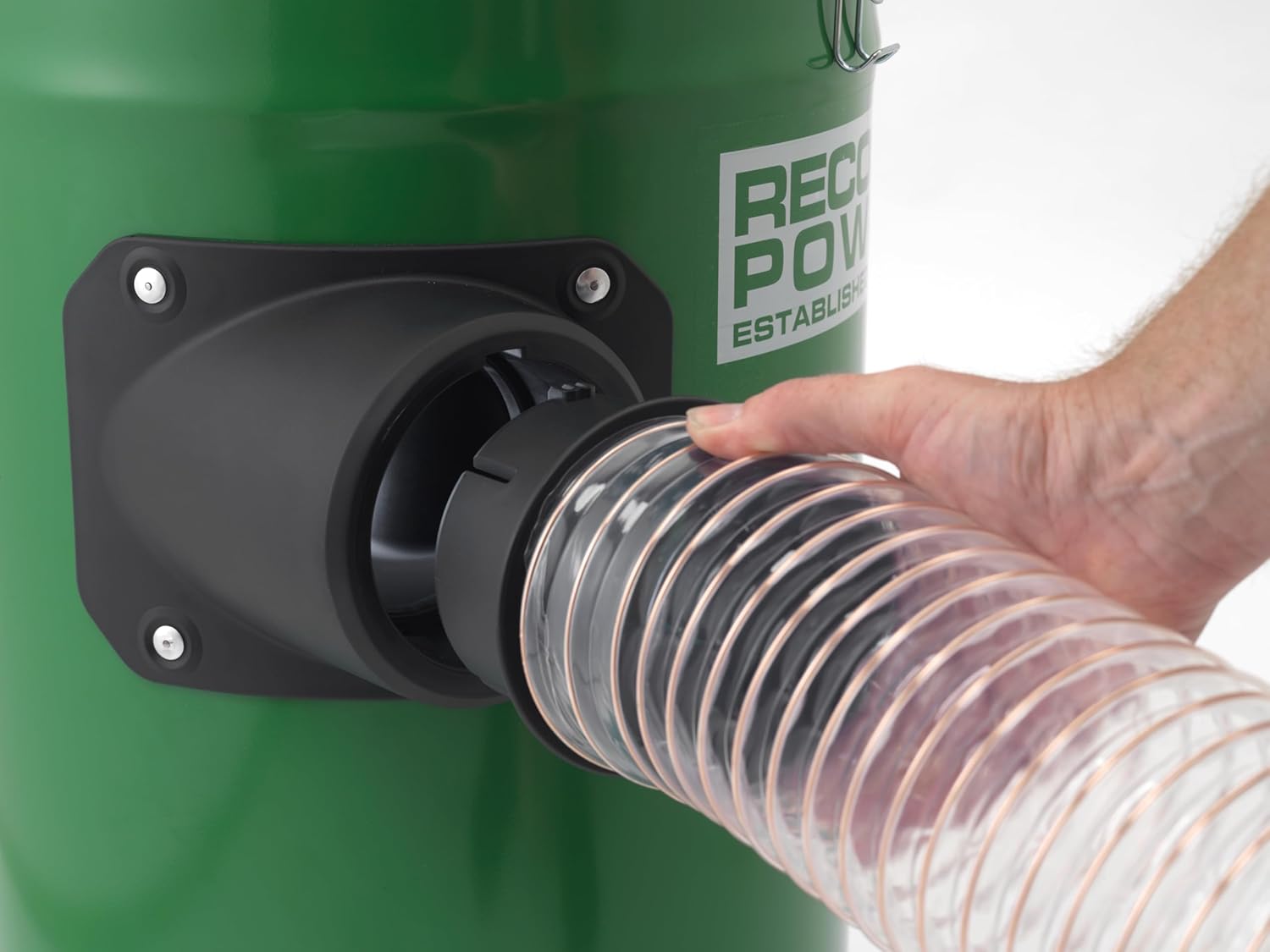 Hand connecting clear flexible hose to green cyclonic dust extractor for tools and home improvement tasks