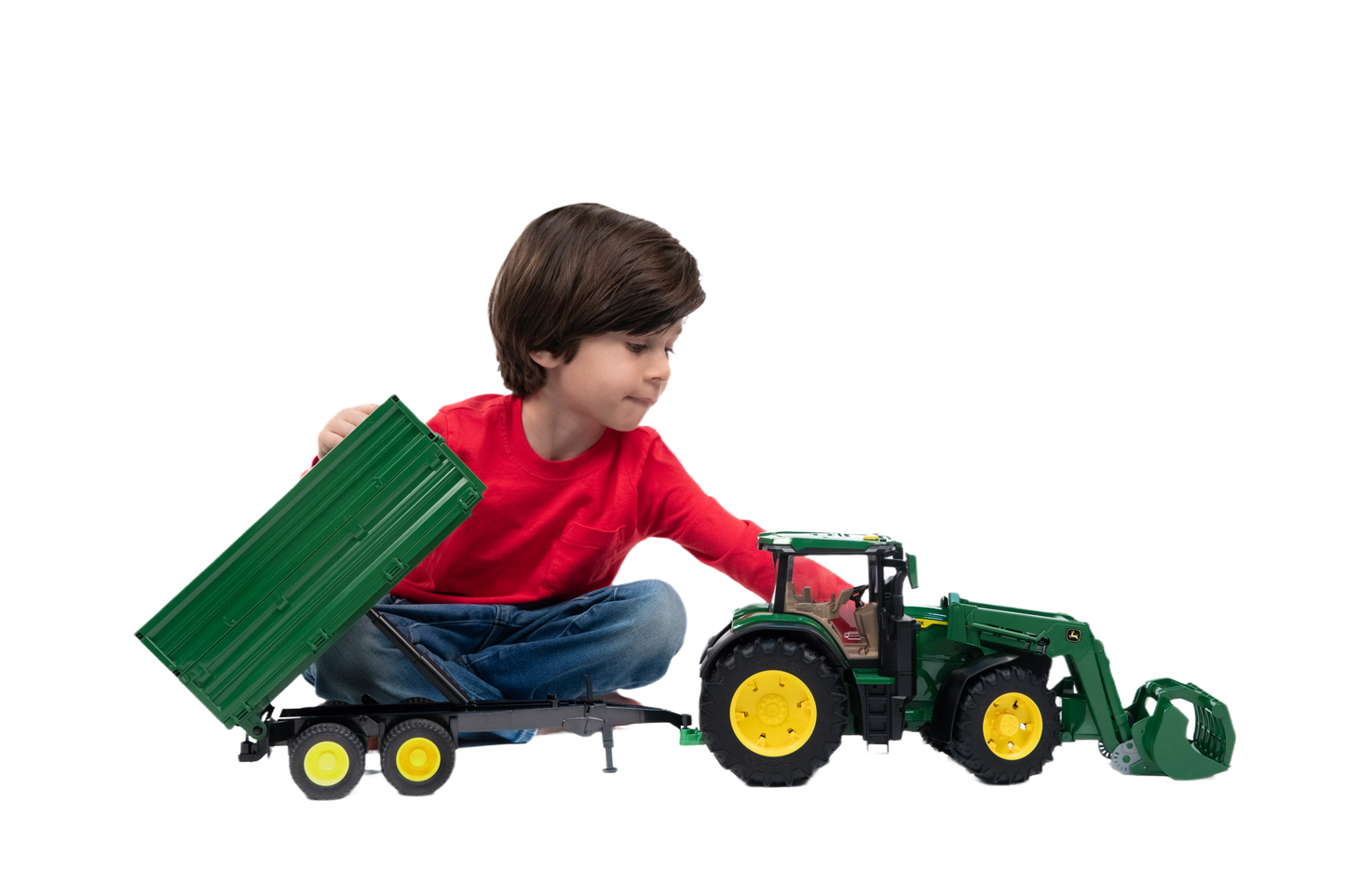 Child playing with green John Deere toy tractor and detachable tipping trailer for farm and home improvement play sets