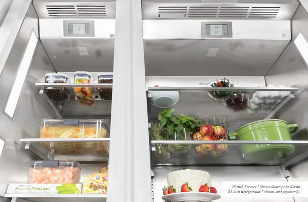 Open built-in freezer column with stainless steel interior, clear shelves, and food items from Thermador Refrigerators collection