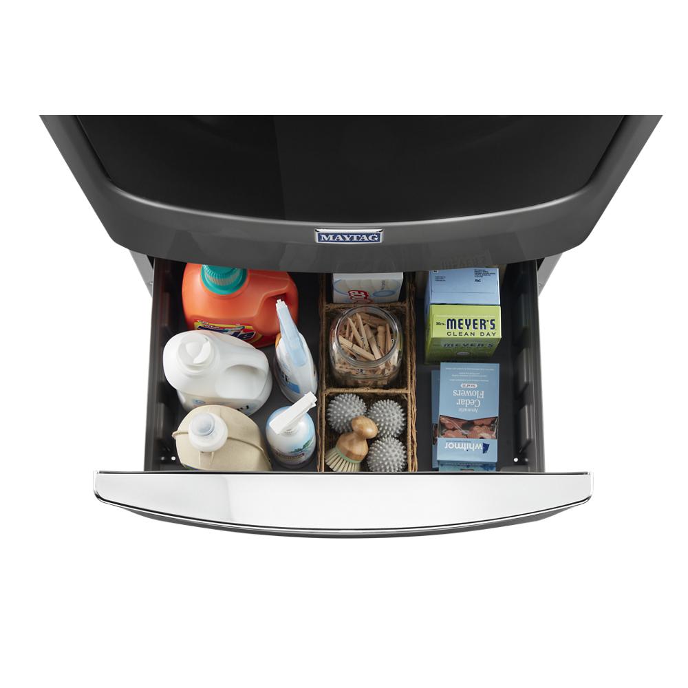 Opened storage drawer beneath front load washer with organized laundry detergents and cleaning supplies inside