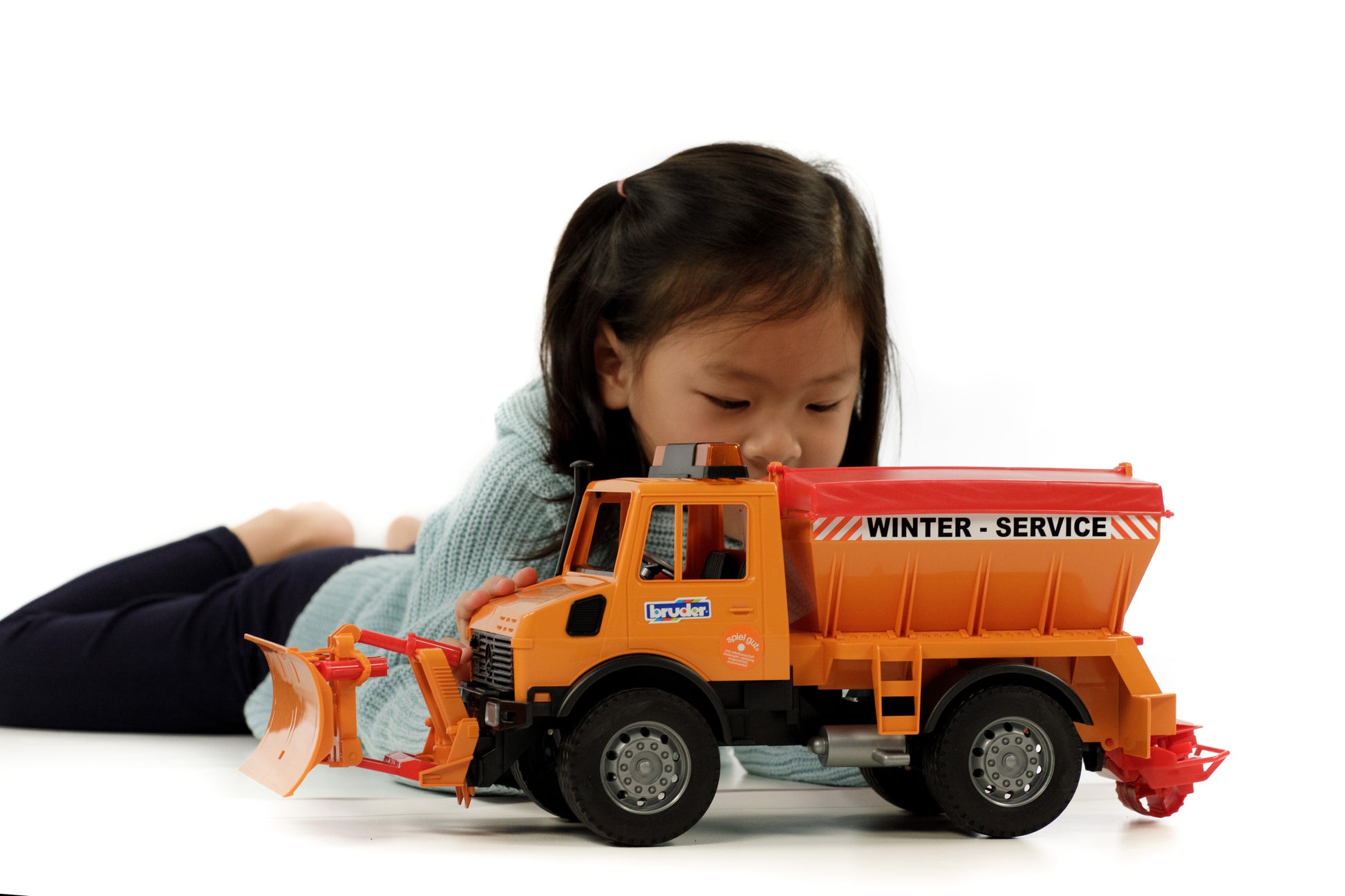 Child playing with Bruder orange winter service truck toy from Vehicles & Remote Controlled Toys collection under $100