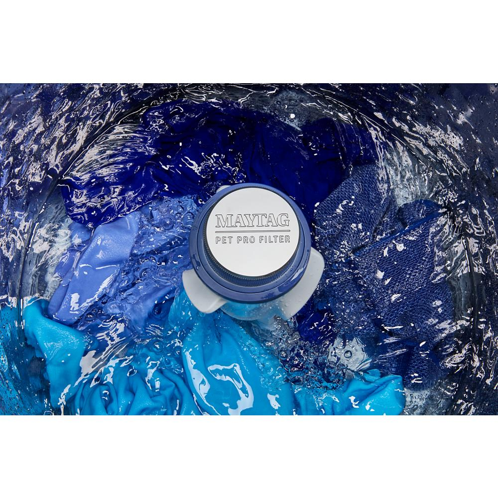 Close-up of Maytag washer agitator with Pet Pro filter and blue clothing inside top load washer drum in use