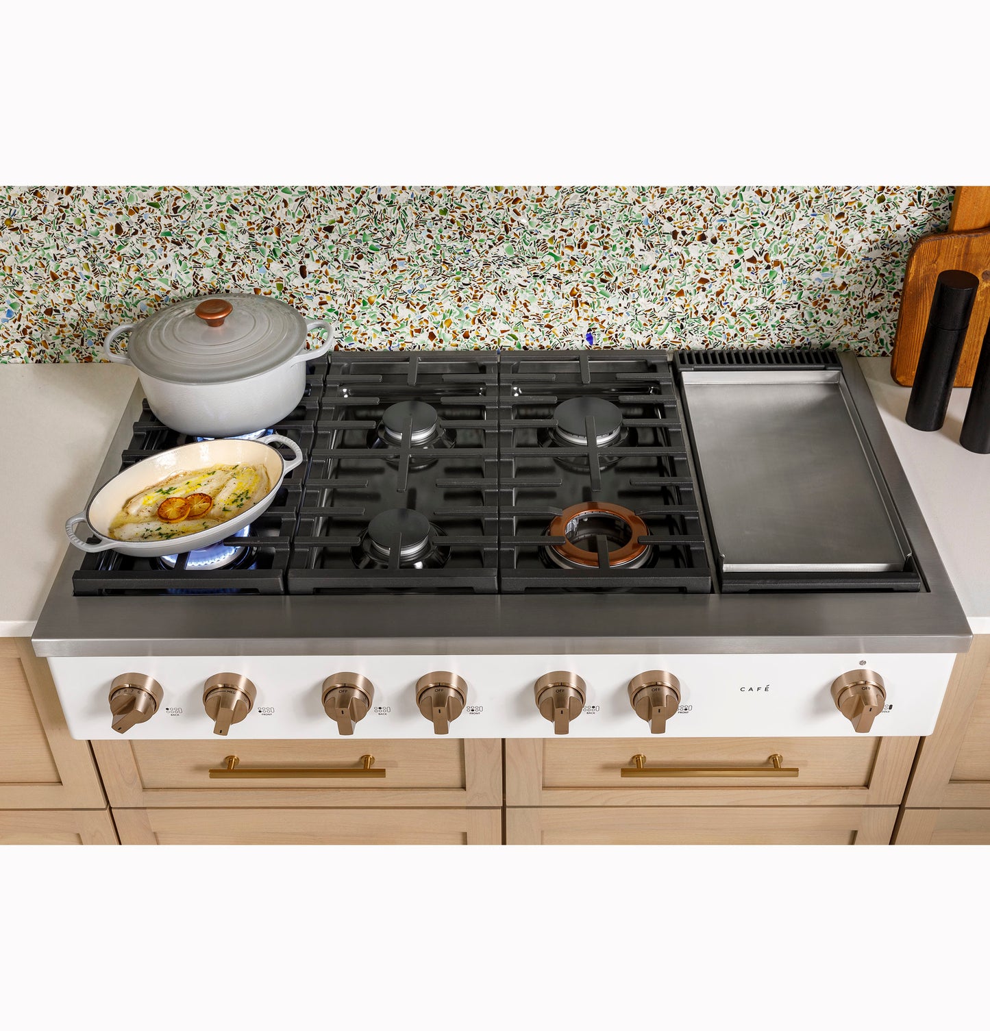 48-inch commercial-style gas rangetop with six burners and integrated griddle in light wood kitchen setting